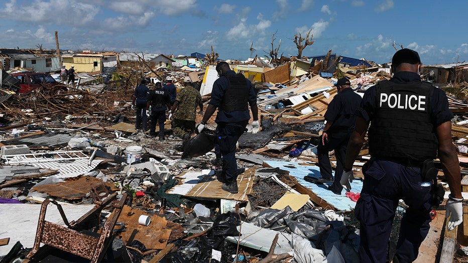 Members of the police join a recovery team looking in the debris in Marsh Harbour, Bahamas one week after Hurricane Dorian. The search for bodies continues, and the death toll is expected to keep rising.