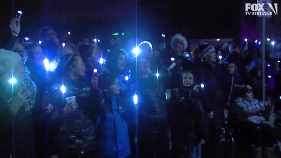 Community spreads holiday cheer by waving lights outside pediatric