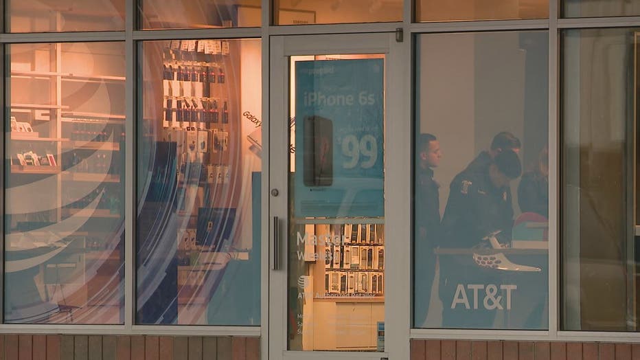 Policemen are seen through the storefront window of the AT&T shop in Sterling Heights.