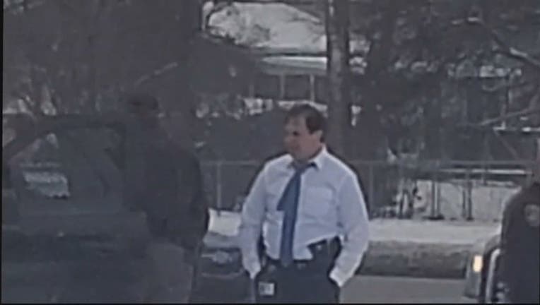 A screenshot from a video of Sheriff Bouchard standing outside a police vehicle