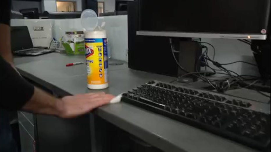 Stratus Franchisee Wiping Down a Desk with a Computer Keyboard