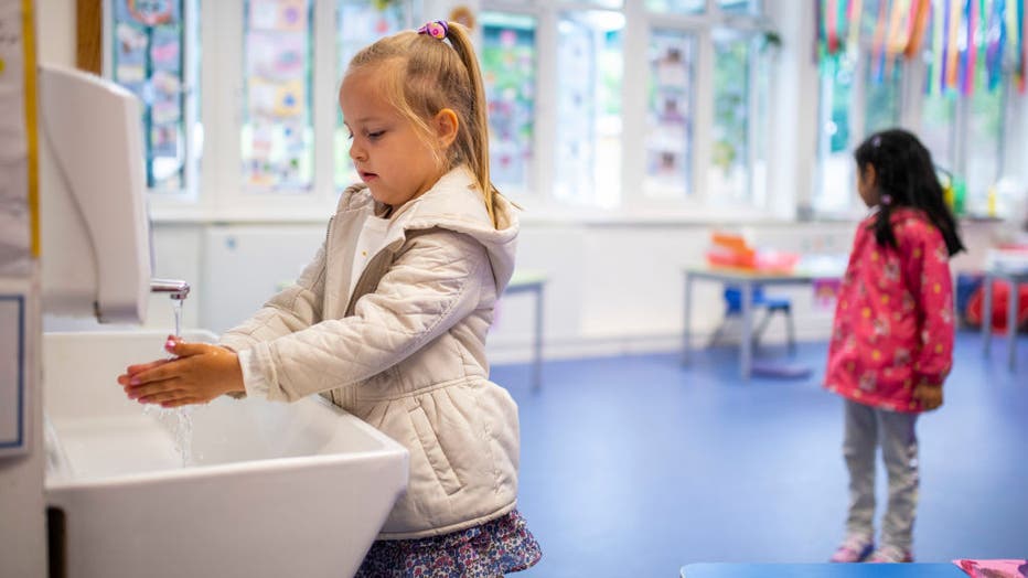 A child maintains social distancing measures while washing hands ahead of a lesson at Earlham Primary School, which is part of the Eko Trust on June 10, 2020 in London, England.