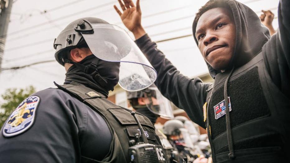 LOUISVILLE, KY - SEPTEMBER 23: A protestor raises his hands in the air during a standoff with law enforcement on September 23, 2020 in Louisville, Kentucky. Protesters marched in the streets after the Kentucky Grand Jury verdict indicted 1 of 3 officers involved in the killing of Breonna Taylor with wanton endangerment. Taylor was fatally shot by Louisville Metro Police officers during a no-knock warrant at her apartment on March 13, 2020 in Louisville, Kentucky. (Photo by Brandon Bell/Getty Images)