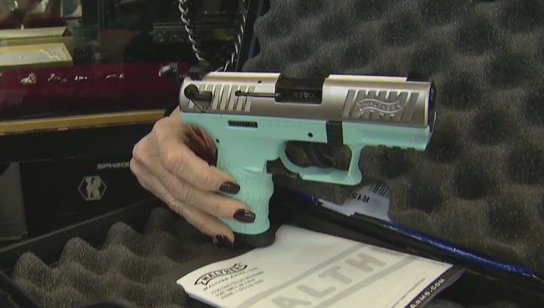 A woman holds a tiffany blue colored handgun