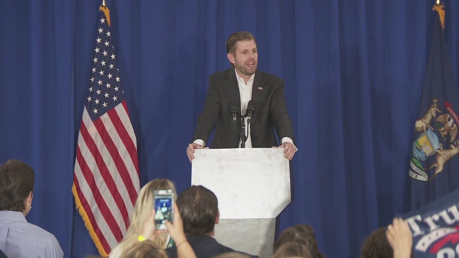 Eric Trump speaks behind a podium on a stage.