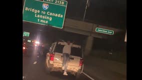 Video shows man hanging, dancing on back of SUV on 94 in Detroit