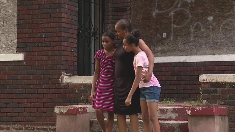 Michelle Danner hugs two of her grandchildren in front of her Land Bank House.