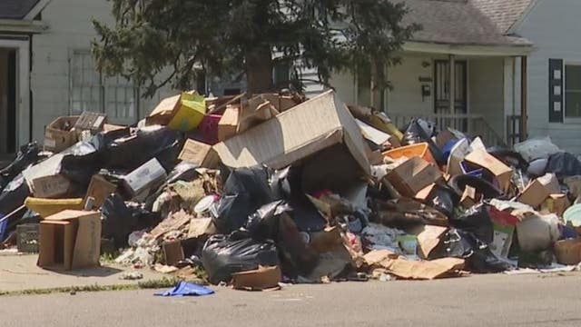 Giant hill of trash left sitting in front of vacant east side Detroit house