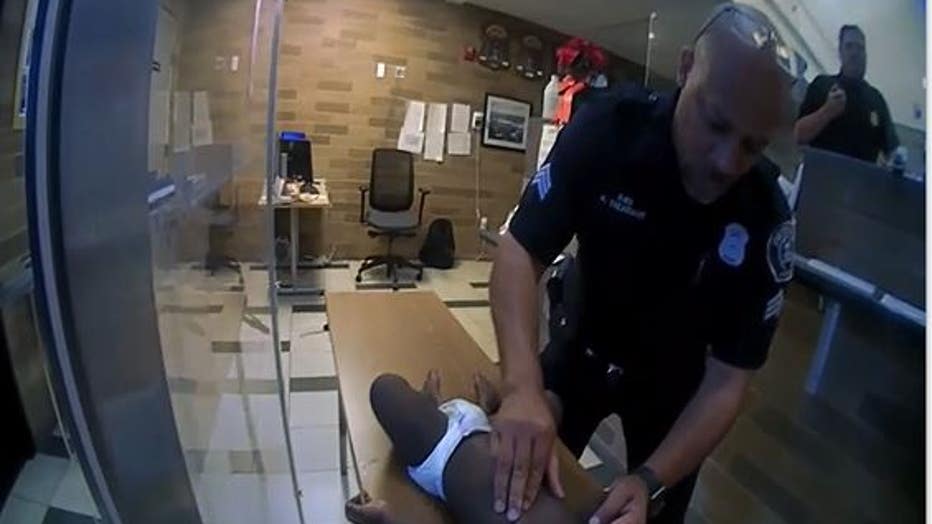 DPD Sgt. Kevin Treasvant begins chest compressions on the child. Photo still courtesy of DPD video.