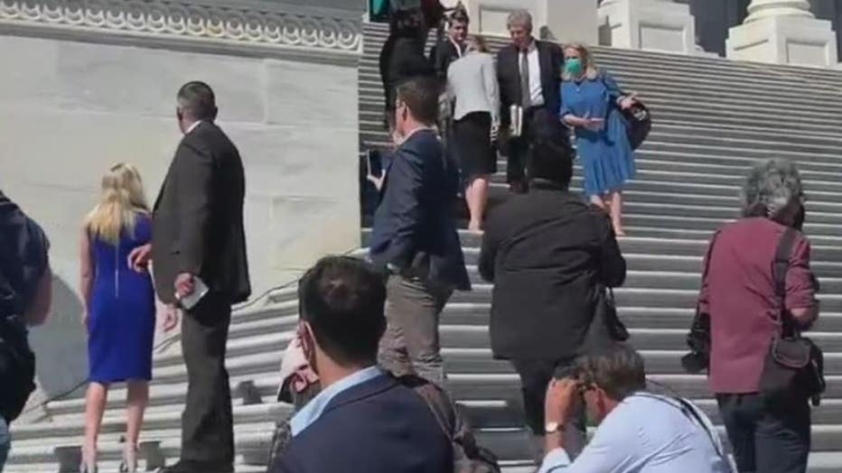 Georgia Rep. Marjorie Taylor Greene (left, bright blue dress) and Michigan Rep. Debbie Dingell (light blue) can be seen on the Capitol steps today arguing abortion rights.