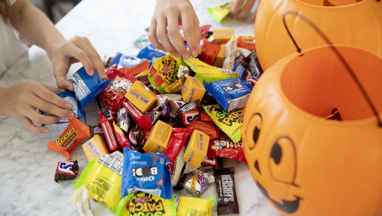 FILE - Two children sort through Halloween candy beside pumpkin-themed treat buckets in an arranged photograph taken in Tiskilwa, Illinois, on Sept. 20, 2020. (Photographer: Daniel Acker/Bloomberg via Getty Images)