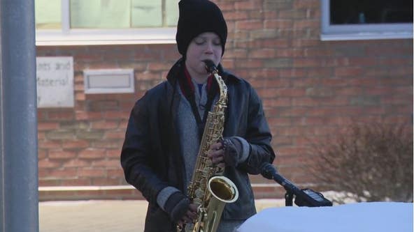 Music with a message: 12-year-old plays saxophone for community outside fire, police, and city hall