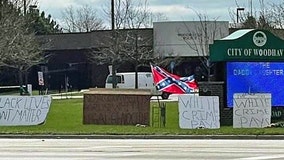 Man protests police with 'White crime pays' signs, Confederate flag in front of department