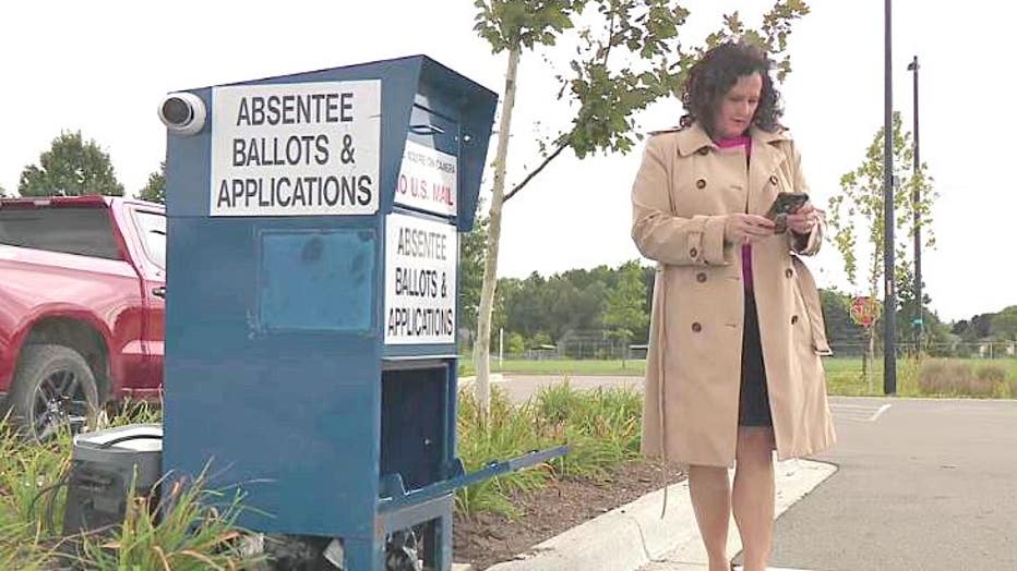 Clinton Township Clerk Kim Meltzer and one of the new camera-quipped ballot drop boxes.