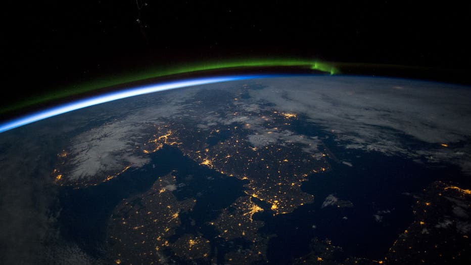 Southern Scandinavia under a full moon, showing the Northern lights aurora.