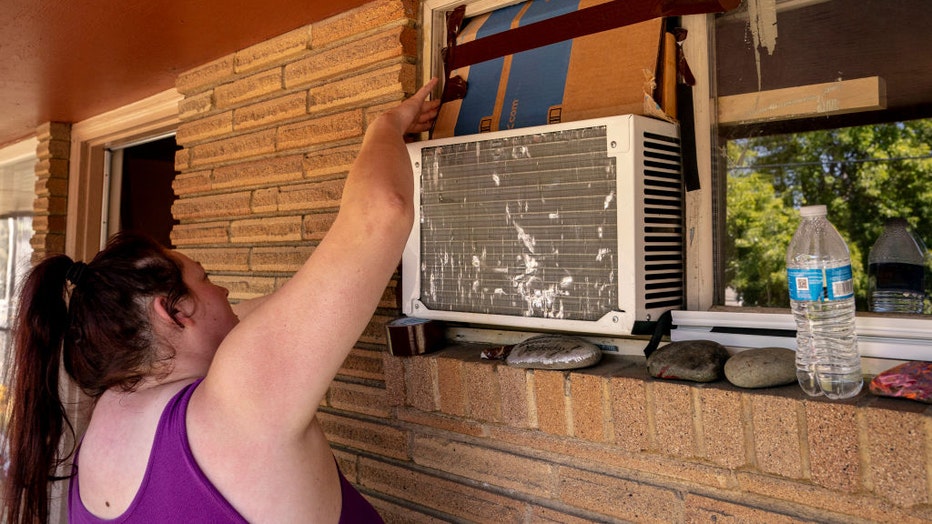 Woman-seals-air-conditioning-unit.jpg