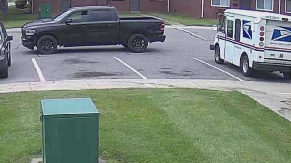 Security camera photo showing the suspects' black Dodge truck on the left.