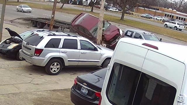 Car flies up, crashes after using empty car hauler as ramp in Detroit