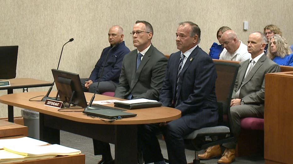 Brian Keely, middle, sits with his attorney Marc Curtis, at right.