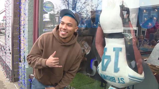 Lions' Amon-Ra St. Brown checks out bakery's life-size cake of his headstand celebration