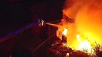 Detroit firefighters battle large fire engulfing 2 houses on city's west side