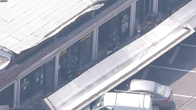 Strip mall facade crashes onto ground, cars