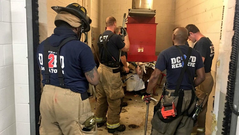 49771338-A man had to be rescued from a trash chute in Washington, D.C. after he dropped in his cell phone, tried to grab it, and fell in after it