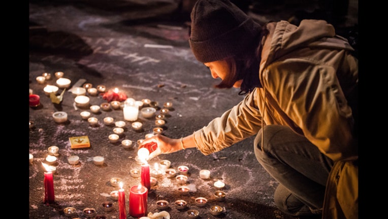 4a408c83-032216_Woman_lights_candle_Memorial_Bourse_de_Bruxelles_Brussels_Belgium_23_1458728715282-401720.jpg