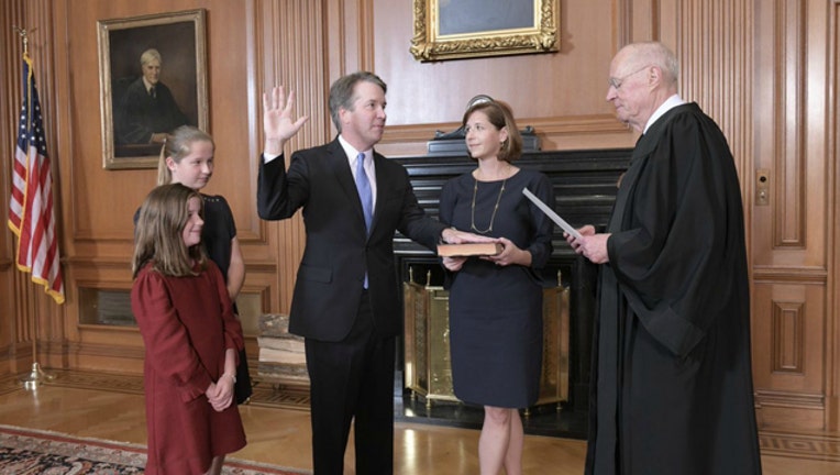 5f3d0c98-Brett Kavanaugh, surrounded by family, is sworn in as the next U.S. Supreme Court Justice.