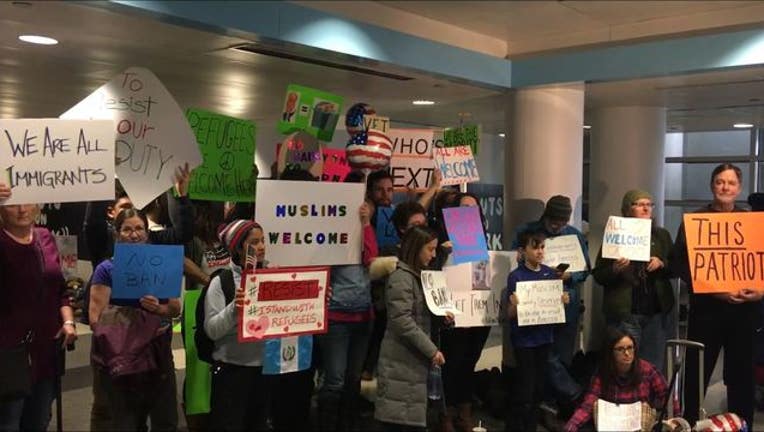 Supporters of Muslims and refugees showed up at O'Hare with welcome signs - Image Demond Miller via Fresco News