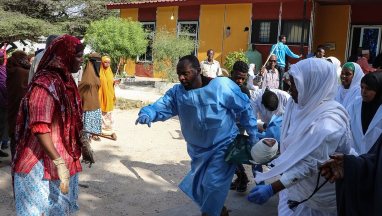 Nurses carry a person, that was wounded during a car bombing attack, at the Madina Hospital in Mogadishu, on December 28, 2019.