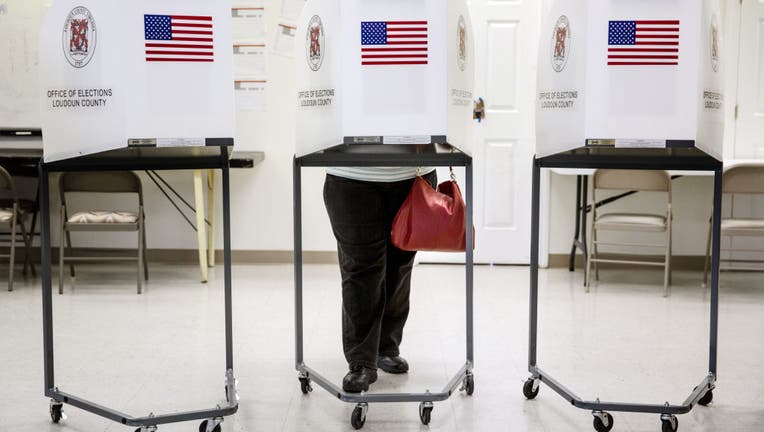 FILE - A voter casts her ballot during Virginia's primary election, March 1, 2016, at the Holy Trinity Lutheran Church in Leesburg, Virginia.