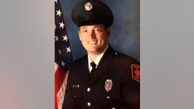 Suburban firefighter dies after construction vehicle falls into water