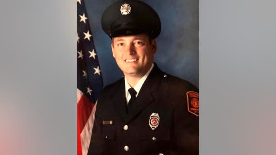 Suburban firefighter dies after construction vehicle falls into water