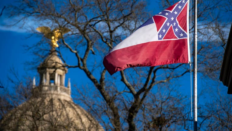 FILE - The Mississippi State Capitol dome is visible in the distance as the flag of the state of Mississippi flies nearby in Jackson, MS on January 10, 2019. 