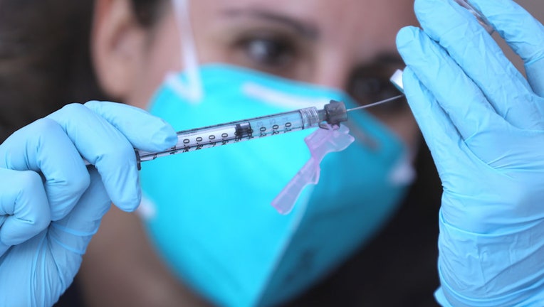 FILE - Registered nurse Emily Enos attempts to extract an extra dose of the Moderna COVID-19 vaccine outside the Los Angeles Mission located in the Skid Row community on Feb.10, 2021 in Los Angeles, California.