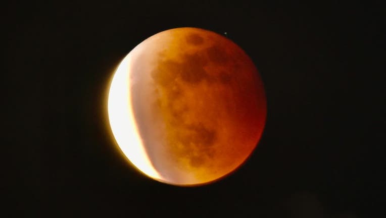 A full blood moon is seen during a partial eclipse in Taipei on May 26, 2021 as stargazers across the Pacific are casting their eyes skyward to witness a rare "Super Blood Moon." (Photo by SAM YEH/AFP via Getty Images)