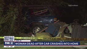 Woman dead after car crashes through home in Gary