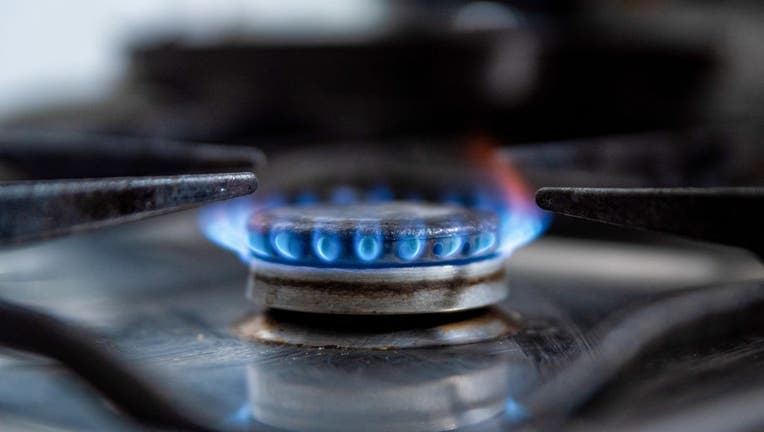 A gas stove lets off a blue flame inside a household kitchen