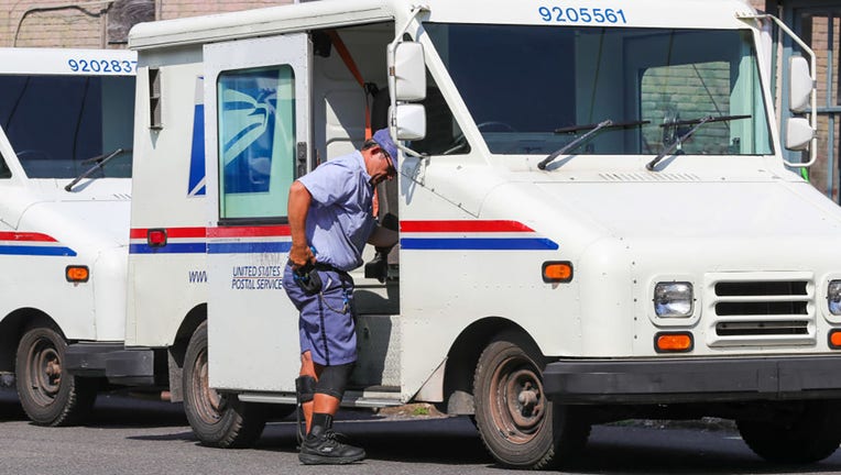 FILE - A United States Postal Service (USPS) worker exits a vehicle on July 20, 2022, in Danville, Pennsylvania. (Photo by Paul Weaver/SOPA Images/LightRocket via Getty Images)