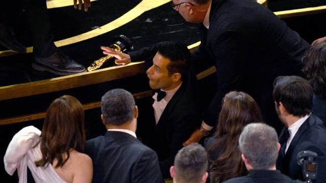 Rami Malek falls, but recovers, after Oscar win