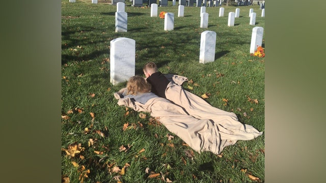 Deceased Army sergeant's sons photographed talking to their father at his grave