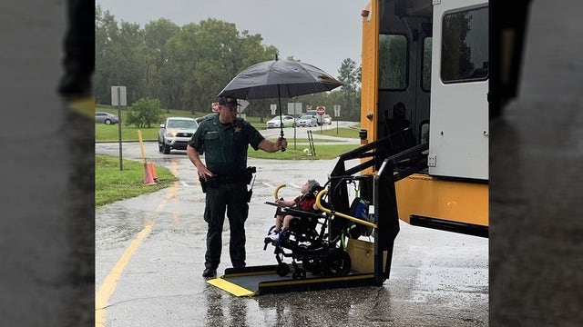 Heartwarming photo shows Florida deputy shielding student in wheelchair from rain