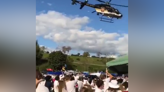 Police chopper stirs debris during Penn State tailgate