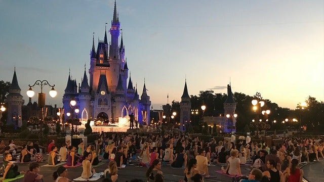 Disney cast members celebrate International Yoga Day in front of Cinderella Castle