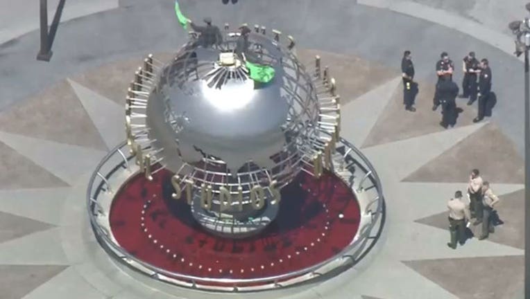 79980ce2-Activists-climb-globe-at-Universal-Studios_1555968163568-407068.jpg
