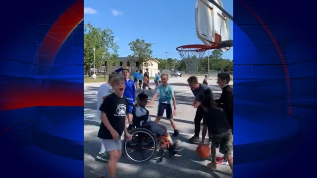 Kids play basketball with wheelchair-bound student