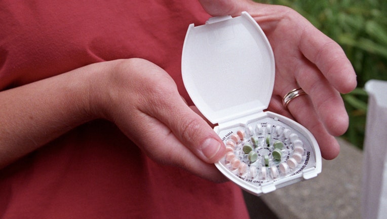 da31b716-A woman holds prescription contraceptives June 13, 2001 in Seattle, Washington (Photo by Tim Matsui/Getty Images)