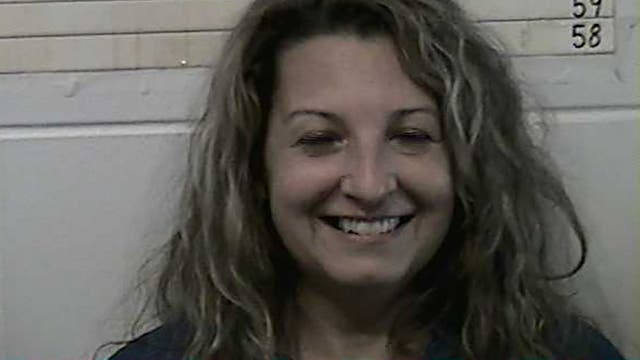 Oklahoma woman, 48, smiles in mugshot after arrest in husband's stabbing death