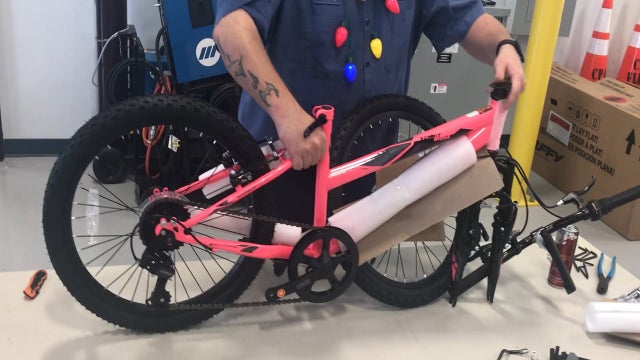 Canaveral Port Authority workers help assemble bikes for kids